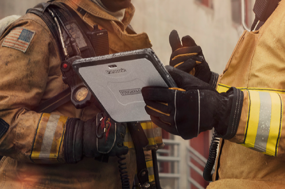 Two Firefighters looks at a TOUGHBOOK tablet at a scene