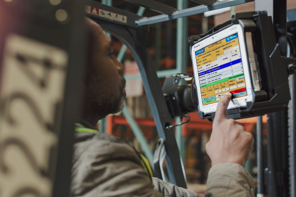 Man in forklift using a mounted TOUGHBOOK tablet