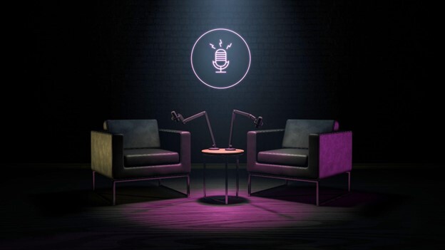 Two empty dark leather chairs in a live streaming studio lit by purple light, with two live broadcast microphones positioned near the chairs.