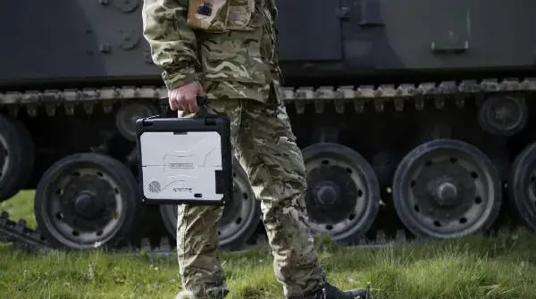 A soldier holds a military laptop.