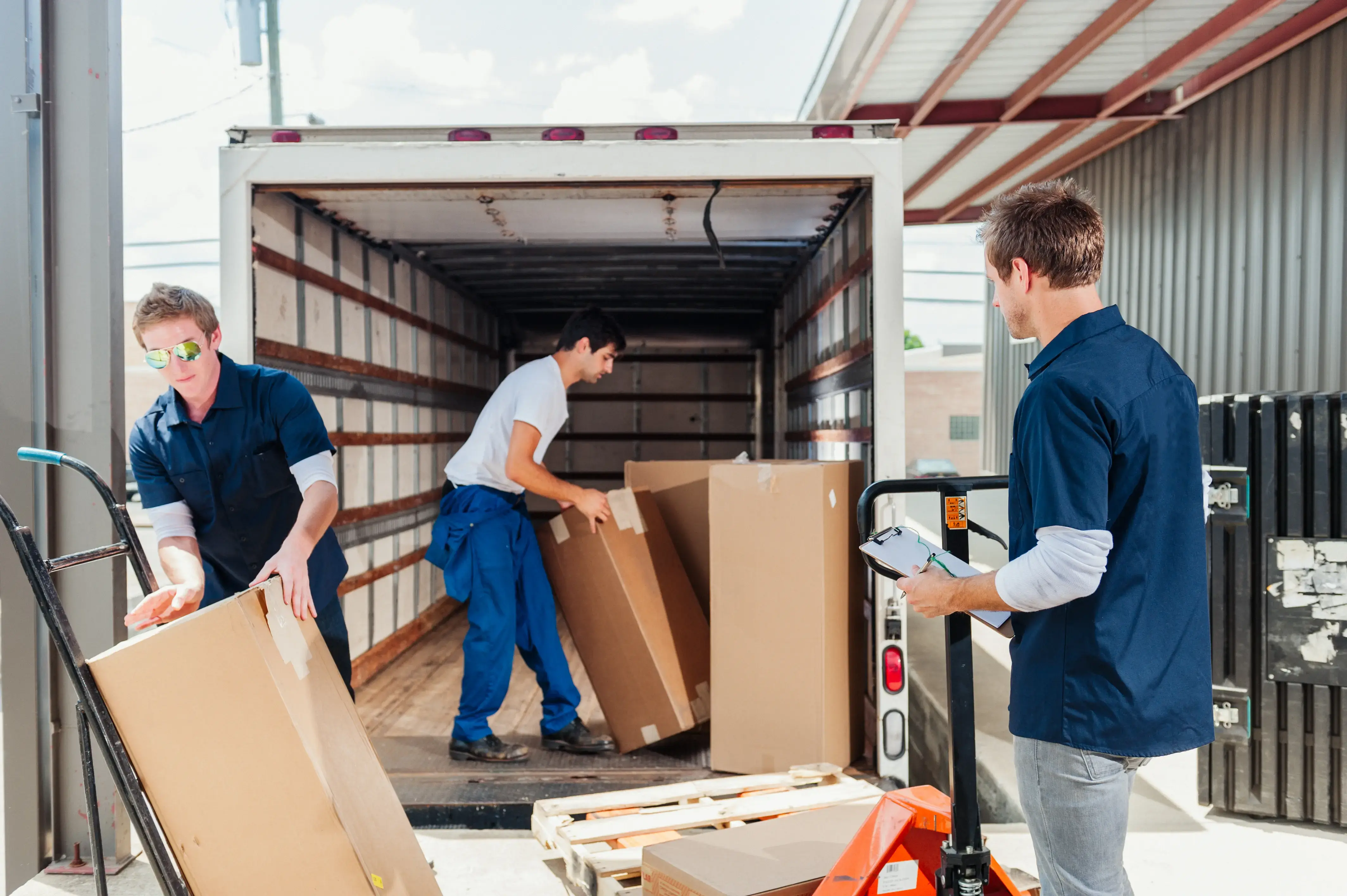 A group of dock workers are loading a delivery truck