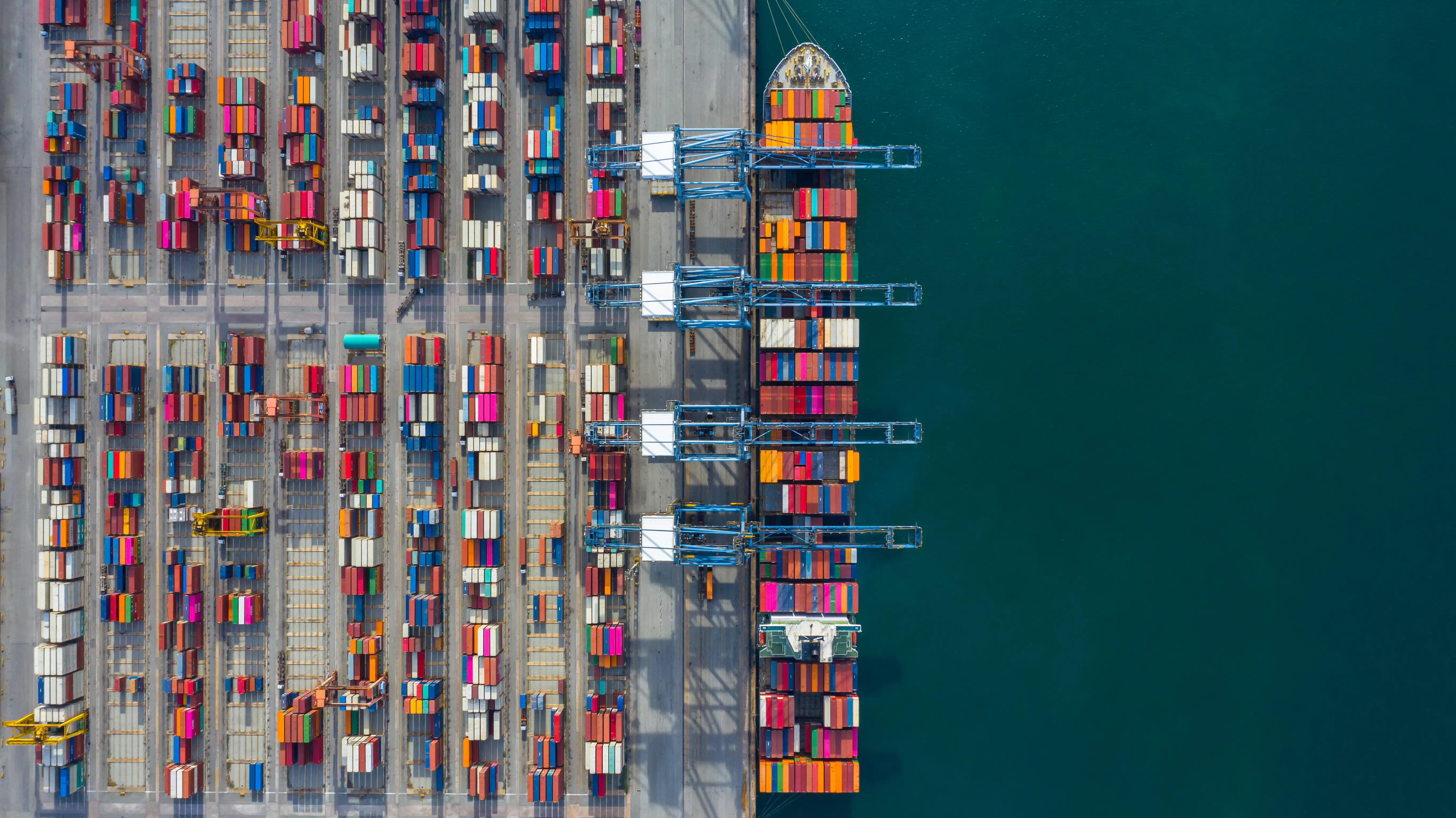 Aerial view cargo ship terminal, Unloading crane of cargo ship terminal, Aerial view industrial port with containers and container ship.