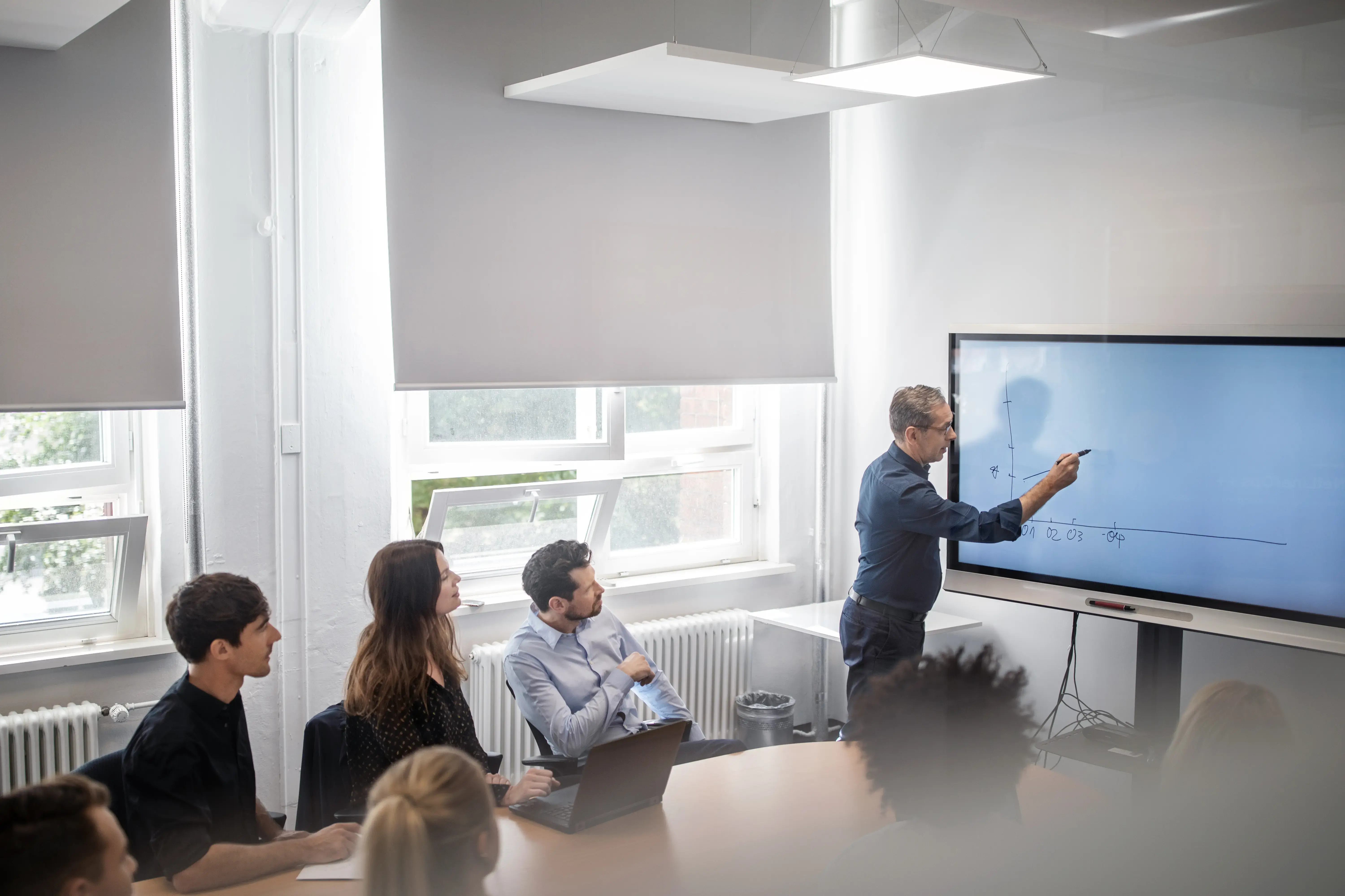 Businessman explaining colleague over graph in office