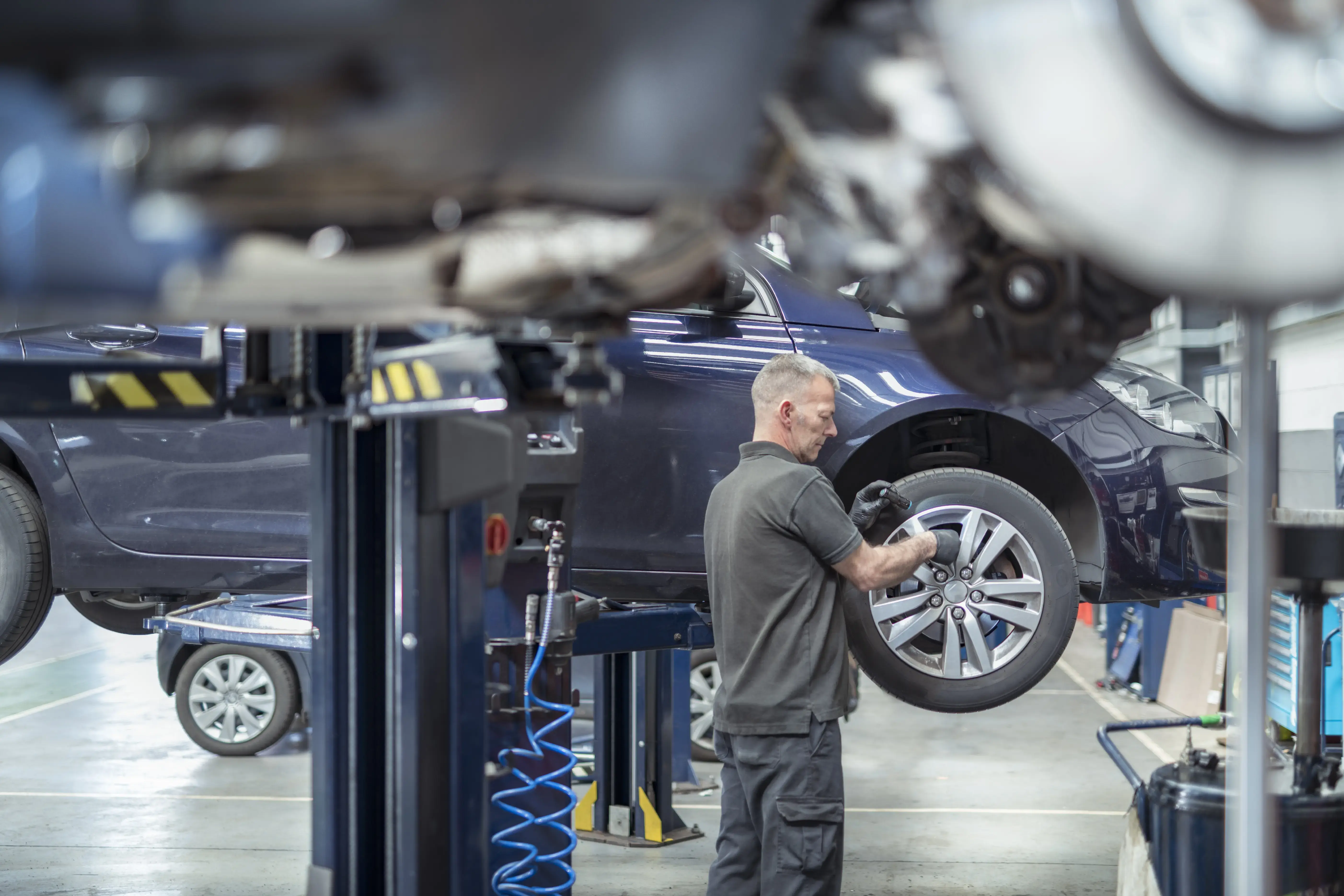 Engineer checking brakes in car service centre