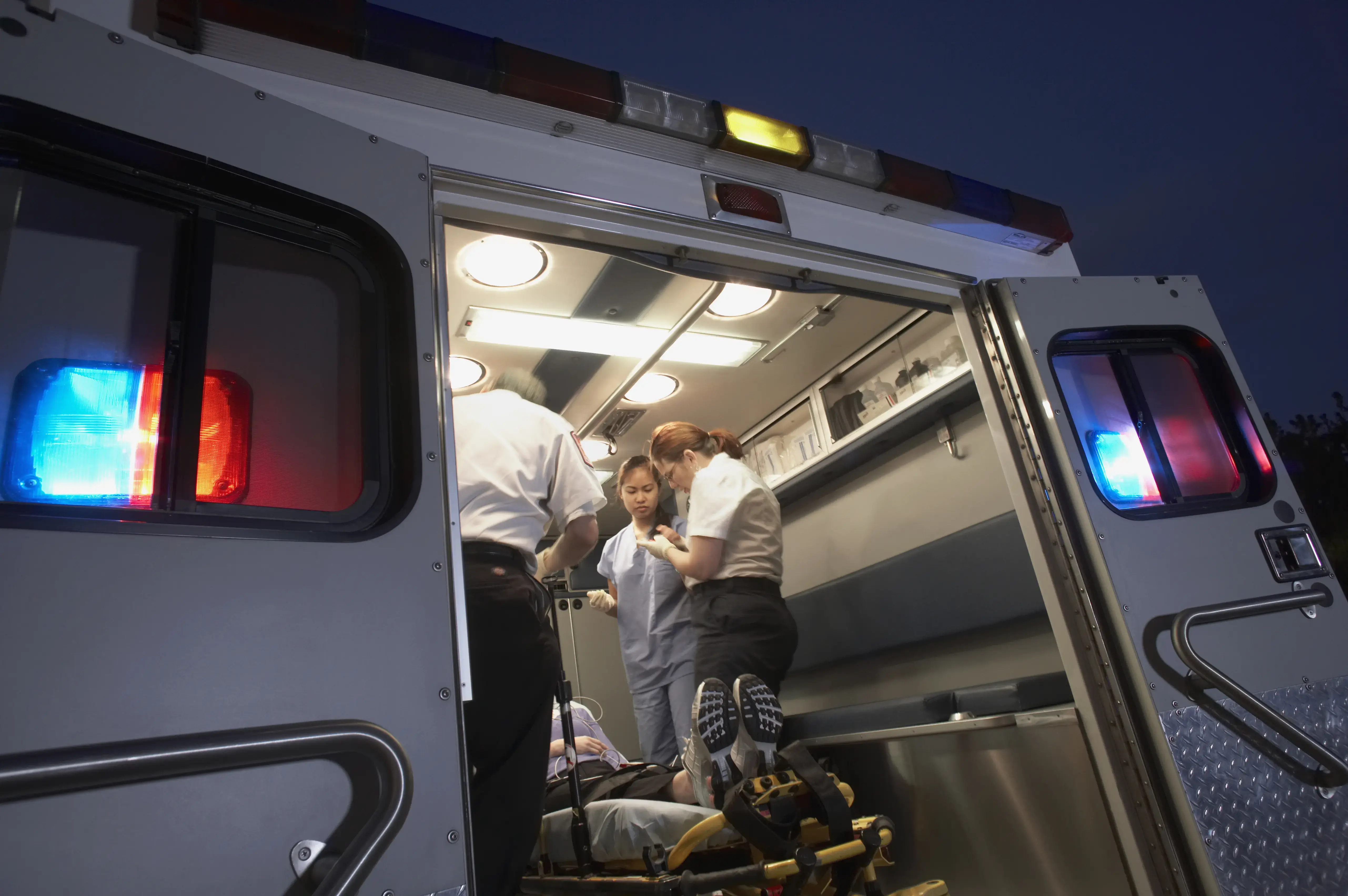 Multi-ethnic medical professionals with patient in ambulance