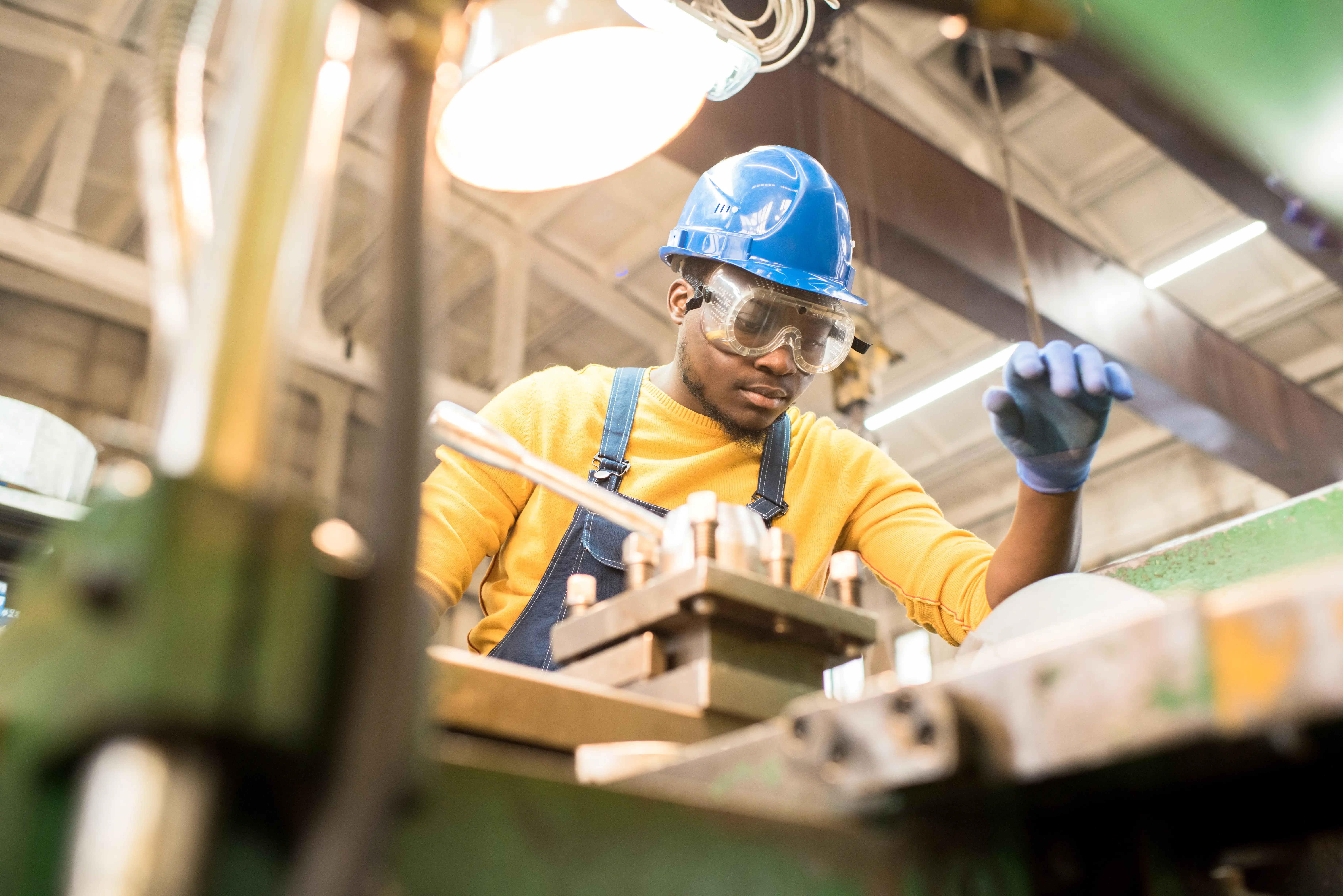 Serious worker repairing manufacturing machine