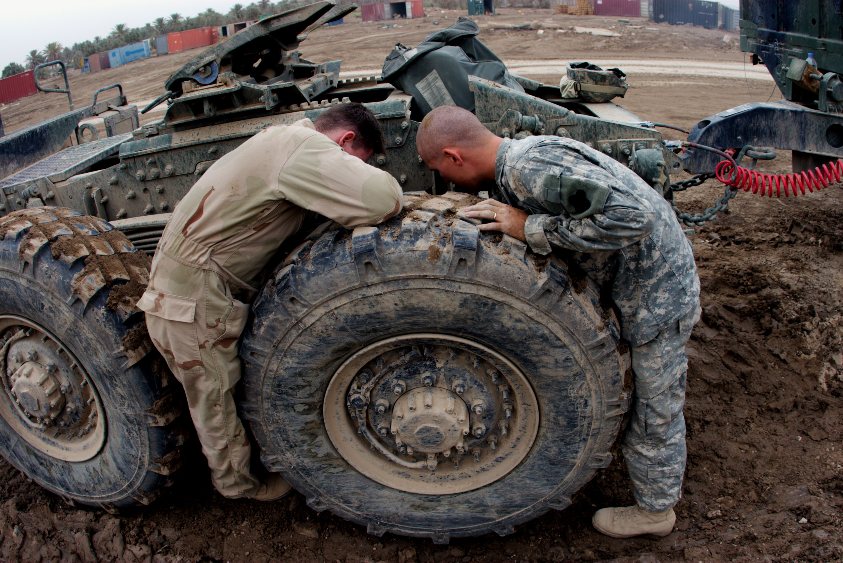 Two men doing maintenance on very large vehicle 