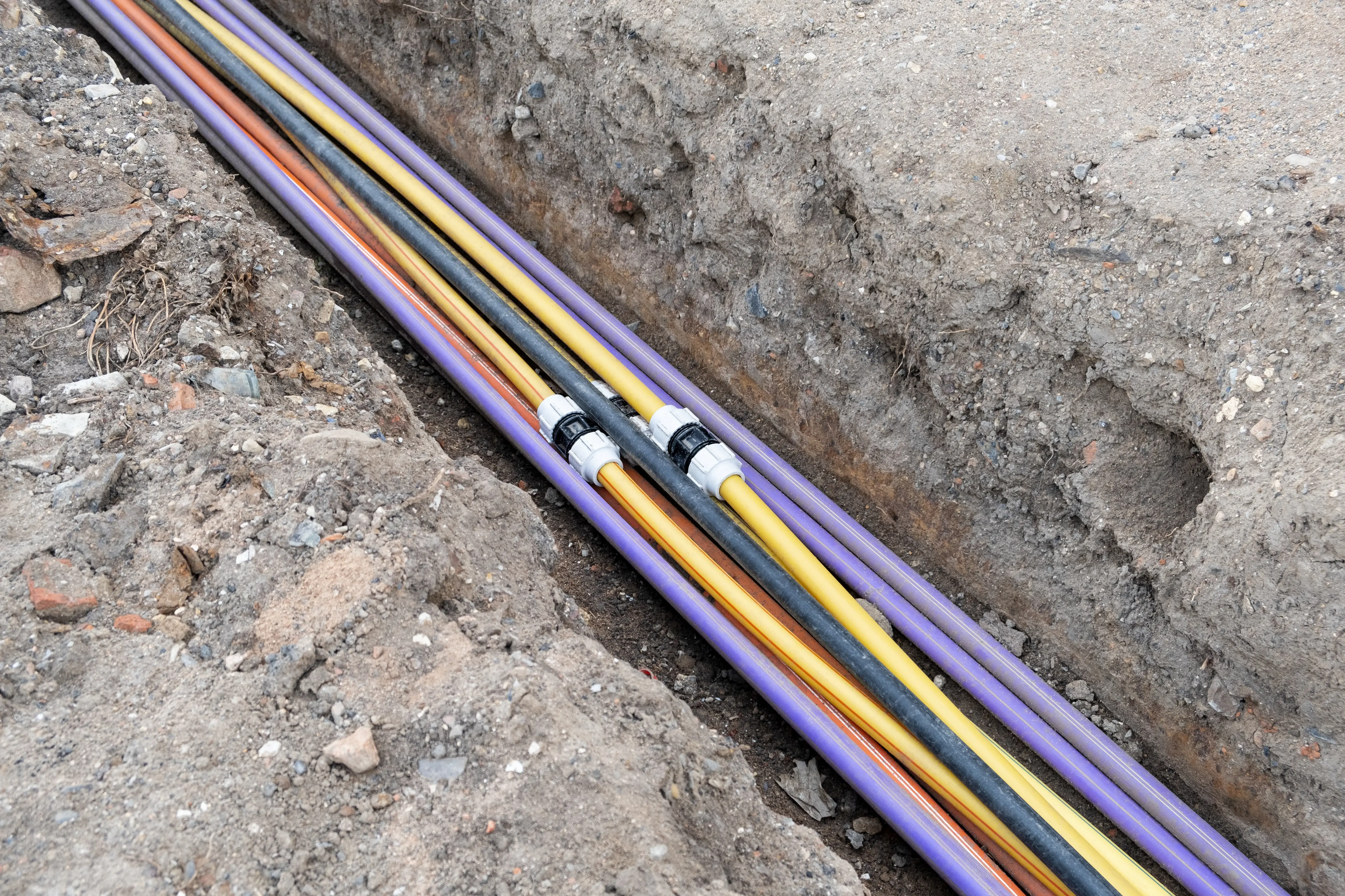 underground electric cable infrastructure installation. Construction site with A lot of communication Cables protected in tubes. electric and high-speed Internet Network cables are buried underground on the street