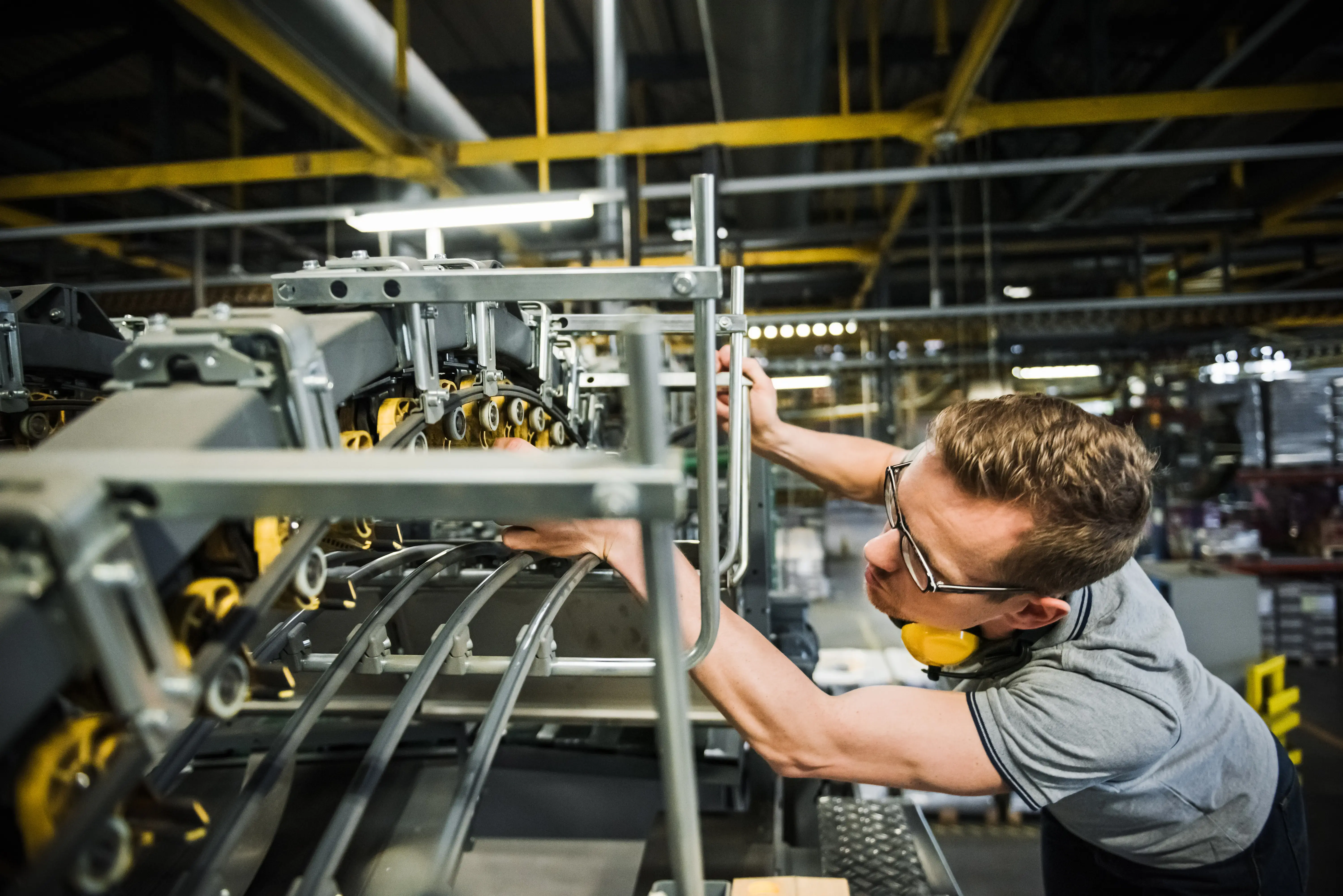 Worker checking machine parts of a conveyor